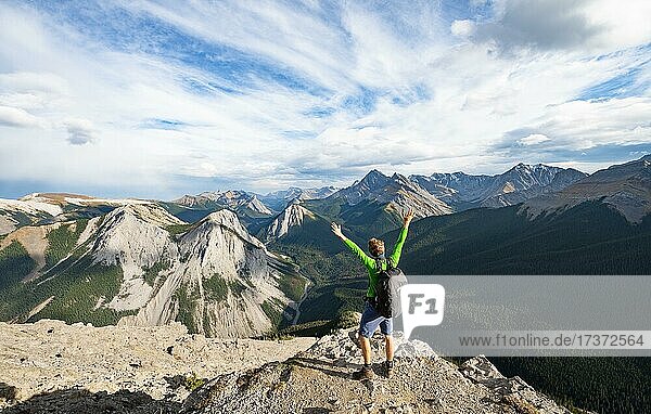 Hiker stretches his arms in the air  mountain landscape with river valley and peaks  peaks with orange sulphur deposits  Overturn Mountain  panoramic view  Nikassin Range  Sulphur Skyline  near Miette Hotsprings  Jasper National Park  Alberta  Canada  North America