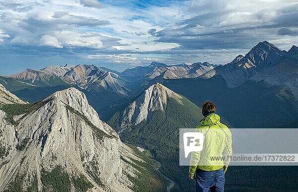 Hiker looking into the distance  mountain landscape with river valley and peaks  peaks with orange sulphur deposits  Overturn Mountain  panoramic view  Nikassin Range  Sulphur Skyline  near Miette Hotsprings  Jasper National Park  Alberta  Canada  North America