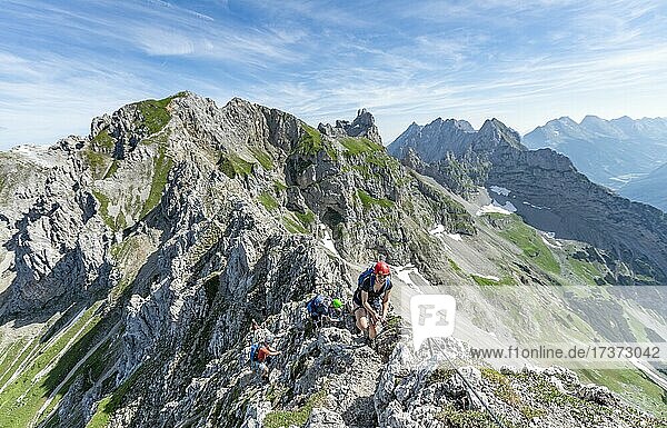 Bergsteiger auf einem Grat an einem gesicherten Klettersteig  Mittenwalder Höhenweg  Blick auf Bergkamm  Karwendelgebirge  Mittenwald  Bayern  Deutschland  Europa