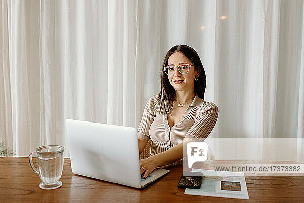 Portrait of young businesswoman working on laptop