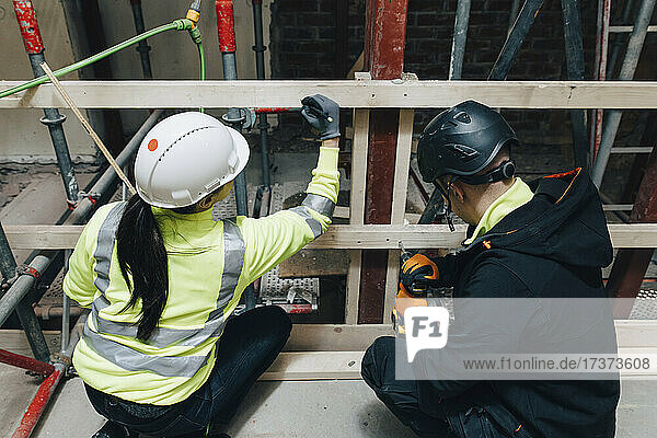 Männliche und weibliche Kollegen arbeiten gemeinsam auf der Baustelle