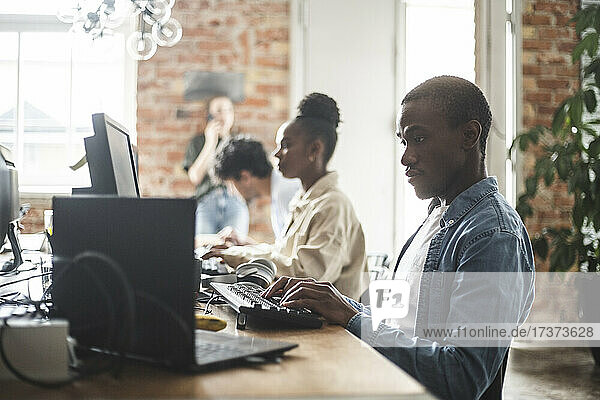 Männliche und weibliche Computerprogrammierer bei der Arbeit in einem kreativen Büro