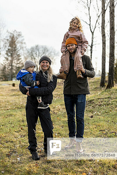Full length portrait of family standing together at park