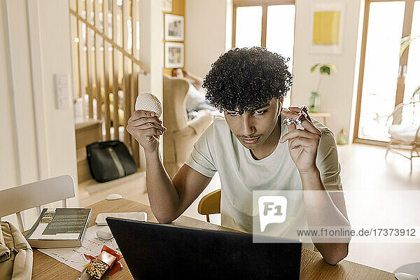 Teenager  der zu Hause am Laptop sitzt