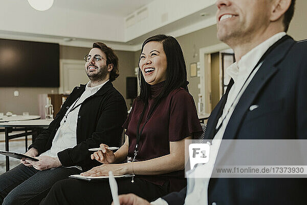 Geschäftsleute lachen bei einer Diskussion während eines Treffens in einer Bildungseinrichtung