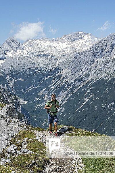 Hiker on hiking trail to Meilerhütte  in the background Reintal and Zugspitzplatt with mountain peaks  Wetterstein Mountains  Bavaria  Germany  Europe