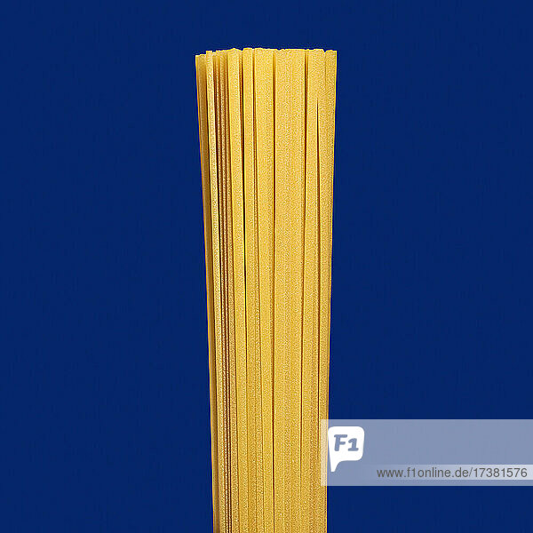 Close up ungekochte Spaghetti Nudeln auf blauem Hintergrund