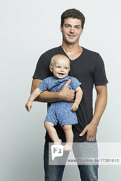 Porträt glücklicher Vater hält Baby Sohn auf weißem Hintergrund