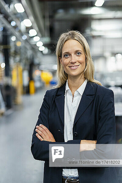 Female manger standing with arms crossed at industry