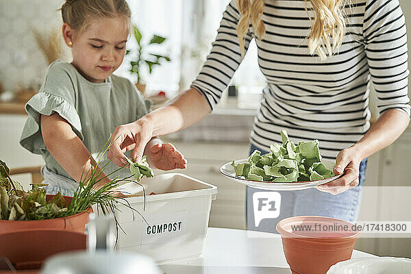 Mother and daughter making compost at home