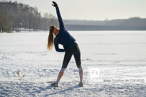 Woman stretching on snow