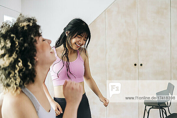 Female friends exercising together at home
