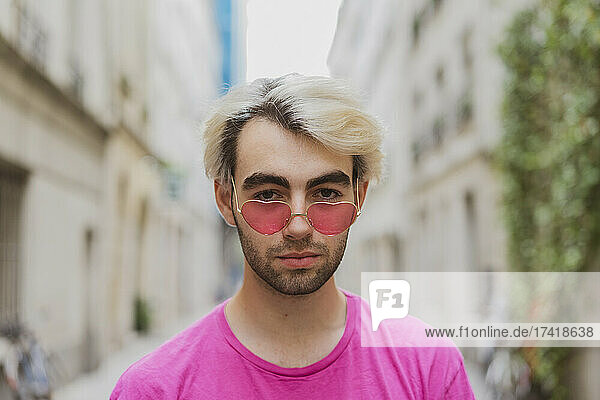 Young gay man wearing heart shaped pink sunglasses