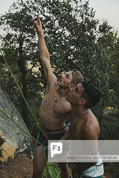 Male climber pointing while guiding athlete