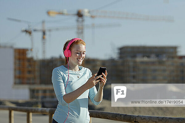 Woman using mobile phone while listening music