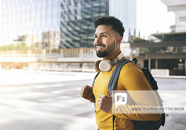 Smiling man with headphones and backpack