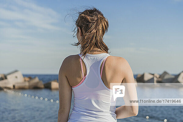 Young woman in sports clothing looking at sea