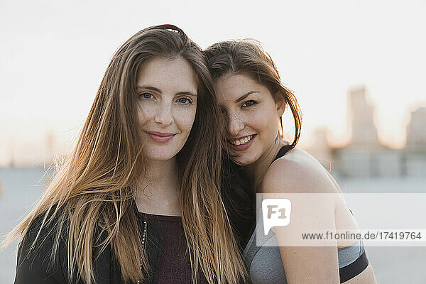 Smiling woman leaning on female friend