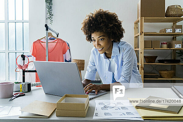 Female fashion designer using laptop while working at studio
