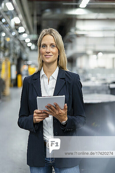 Female professional with digital tablet at industry