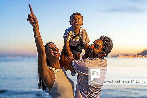 Glückliches erwachsenes Paar mit Sohn  das am Strand genießt