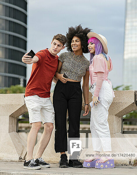 Young man taking selfie with female friends