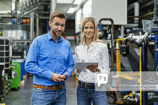 Business professionals with digital tablet standing at industry