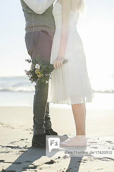 Newlywed couple standing together on beach