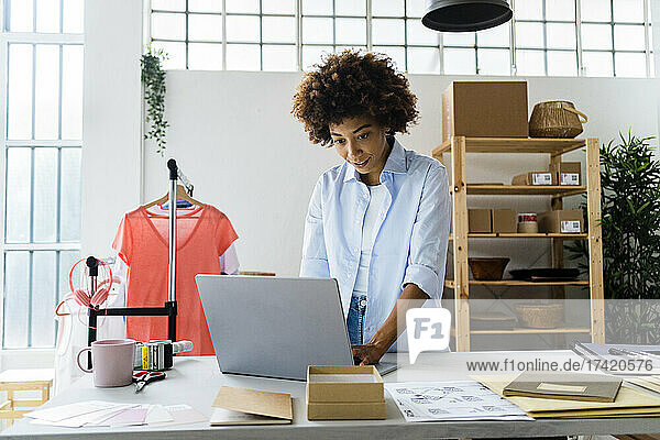 Female entrepreneur using laptop at studio