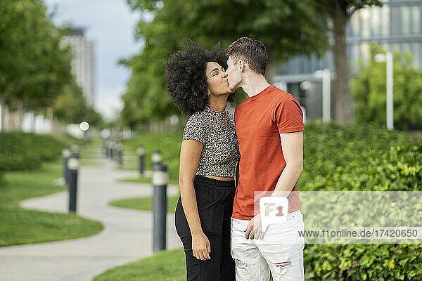 Multi-ethnic couple kissing each other at park