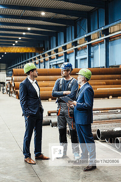 Male business professionals having discussion in metal industry