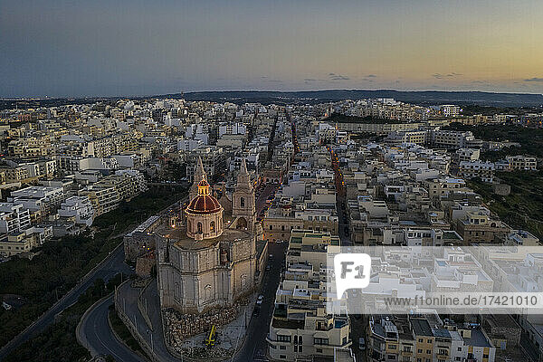 Malta  Northern Region  Mellieha  Aerial view of town at dusk with Parish Church of Nativity of Virgin Mary in foreground