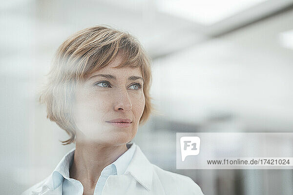 Female pharmacist contemplating at medical store