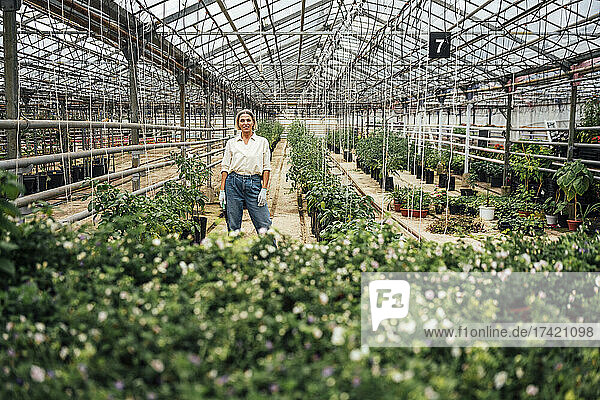 Female agriculture expert standing at plant nursery