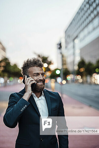 Mature businessman smiling while talking on mobile phone