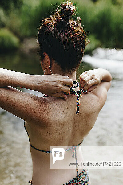 Woman tying bikini top string