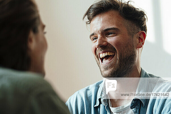 Man laughing while looking at woman