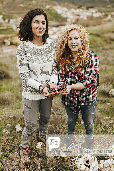 Mature woman with female friend holding acorns