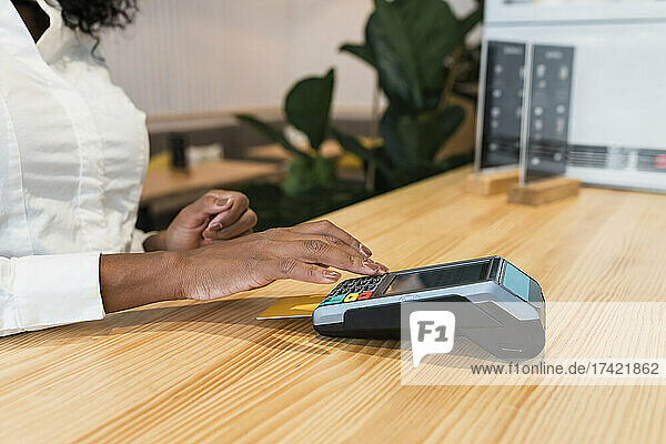 Junge Geschäftsfrau zahlt im Café per Kreditkarte
