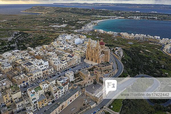 Malta, Northern Region, Mellieha, Aerial view of coastal town with Parish Church of Nativity of Virgin Mary and Ghadira Bay in background