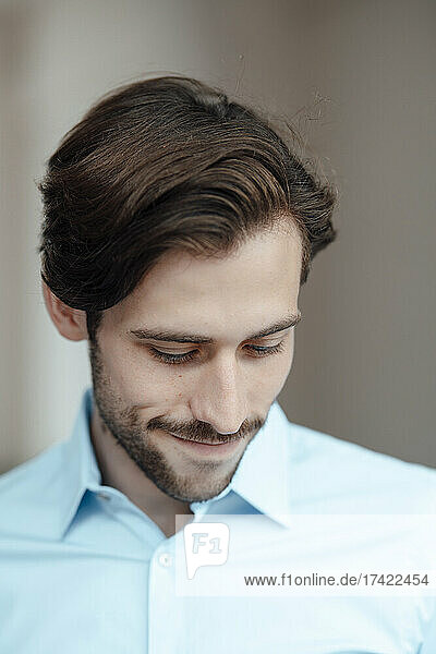 Smiling businessman with brown hair and stubble