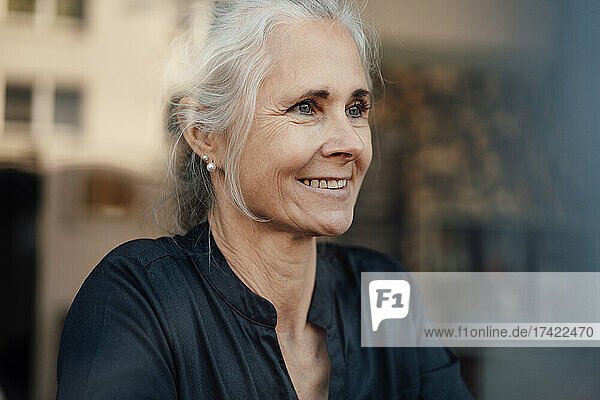 Smiling woman looking through cafe window