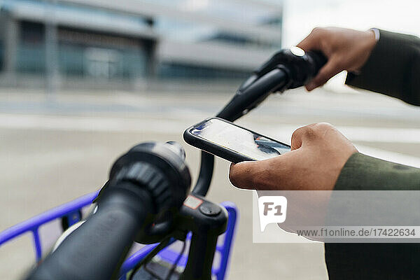 Businessman unlocking bicycle through smart phone