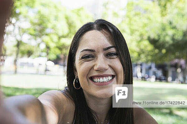 Lächelnde schöne Frau  die Selfie im öffentlichen Park macht
