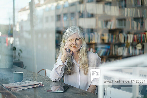 Smiling businesswoman looking through cafe window