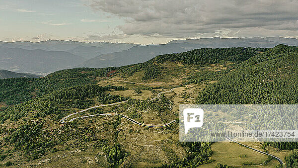 Aerial view of country road stretching through forested landscape of Pyrenees