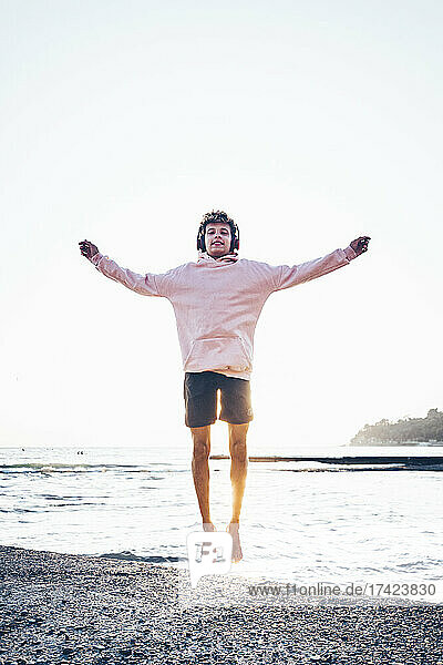 Carefree young man jumping at beach