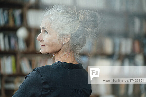 Mature woman with gray hair bun in cafe