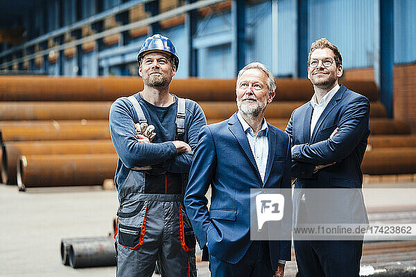 Thoughtful male professionals standing at metal industry