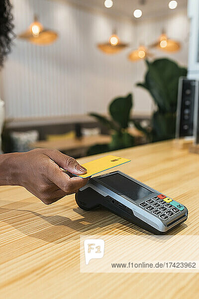 Businesswoman making payment through credit card at coffee shop